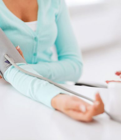 healthcare and medical concept - doctor or nurse with patient measuring blood pressure